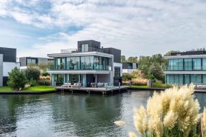 een groot huis aan het water met een meer bij Harbour Villas Zeeland in Arnemuiden