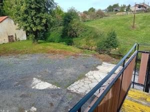 uma vista para um quintal a partir de um alpendre com uma cerca em Grand appartement avec terrasse em Wignehies