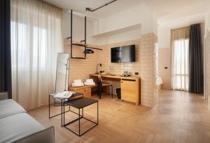 a living room with a table and a desk at Re Versiliana Hotel in Marina di Pietrasanta