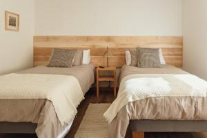 a bedroom with two beds and a table at PURA Hotel in Coihaique