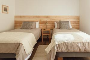 1 dormitorio con 2 camas y mesa en PURA Hotel, en Coyhaique