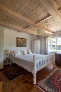 にあるDobilynė – privati ir jauki šeimos kurta sodybaの木製の天井のベッドルーム1室(白いベッド1台付)