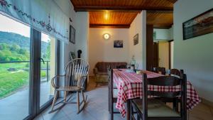 een eetkamer met een tafel en stoelen en een raam bij Apartman Galerija in Lokve