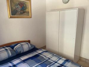 een slaapkamer met een bed en een witte kast bij Apartman Galerija in Lokve