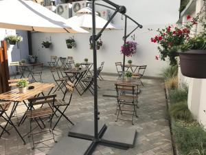 een patio met tafels en stoelen en een parasol bij Residence Vysta in Praag