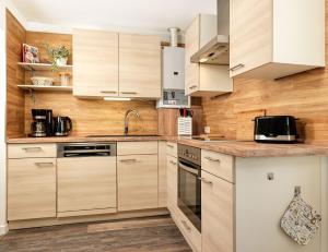 eine Küche mit weißen Schränken und Holzwänden in der Unterkunft Dat Köhnsche Hus in Kirchdorf
