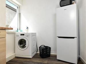 una lavadora y secadora en una cocina junto a una nevera en Dat Köhnsche Hus, en Kirchdorf