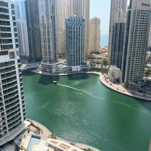um barco em um rio em uma cidade com edifícios altos em Pure Living - Spacious & Relaxing 2BR Apartment in Dubai Marina em Dubai