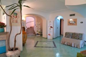 a living room with a couch and a palm tree at Hotel Albatros in Ischia
