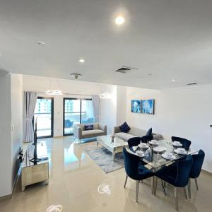 uma sala de estar com uma mesa e cadeiras azuis em Pure Living - Spacious & Relaxing 2BR Apartment in Dubai Marina em Dubai