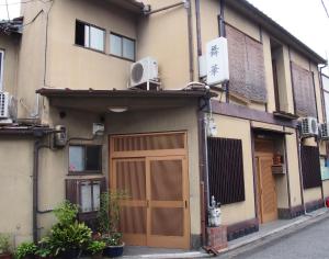 un edificio con una puerta marrón en una calle en Maika - renting a whole house 1日1組限定の一棟貸しの宿, en Kioto