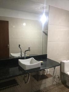 ein Bad mit einem Waschbecken und einem Spiegel in der Unterkunft Casa especial em Itacaré in Itacaré