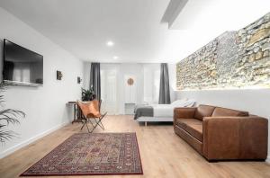 sala de estar con sofá y cama en 32 De Agosto ROOMS, en San Sebastián