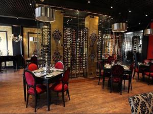 a dining room with tables and chairs and a wine cellar at The hub - Hotel & Restobar in Atyrau