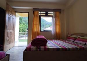 1 dormitorio con cama y ventana grande en Lingtam Yangsel River Retreat by StayApart, en Lingtām