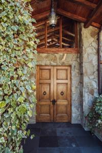 - une porte en bois dans un bâtiment en pierre avec du lierre dans l'établissement PURA Hotel, à Coyhaique