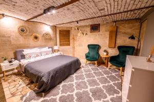 a bedroom with a bed and two chairs and a table at Arena View Premium Studio in Cluj-Napoca