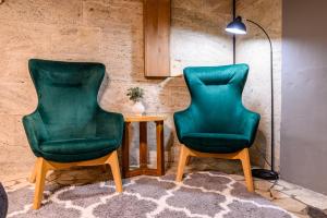 two green chairs and a table in a room at Arena View Premium Studio in Cluj-Napoca