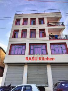 ein großes Gebäude mit einem Rishi-Küchenschild drauf in der Unterkunft OYO HOTEL RASU in Imphal