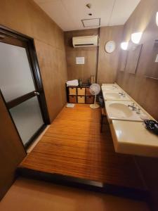 a bathroom with a row of sinks and a mirror at Hotel Seagull in Izumi-Sano