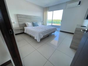 1 dormitorio con cama y ventana grande en Puerto Azul Hotel & Marina, en Puntarenas