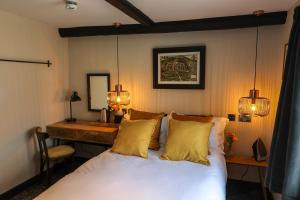 a bedroom with a bed and a desk with lights at The Turks Head in Exeter