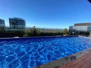 a swimming pool on the roof of a building at Cozy 2B2B Apartment with Free Parking & Penthouse Pool in Box Hill