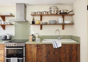 a kitchen with a sink and a stove at The Hayloft at Moor Farm in Godshill