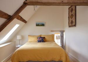 - une chambre mansardée avec un lit jaune dans l'établissement The Hayloft at Moor Farm, à Godshill