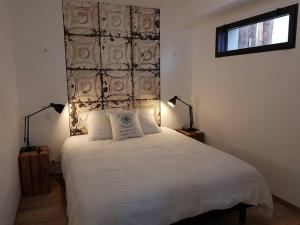 una camera da letto con un grande letto bianco con due lampade di L'Escapade T1 de 30 m2 neuf. a Granville
