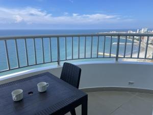 a balcony with a table and a view of the ocean at Apartamento en Cartagena Makrotours in Cartagena de Indias