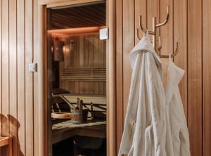 a white wedding dress hanging on a rack in a bathroom at HEINhotel vienna airport in Schwechat