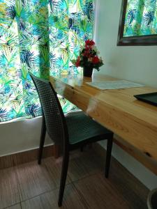 una mesa de madera con una silla y un jarrón de flores en BBoutique Hotel en Lapu Lapu City