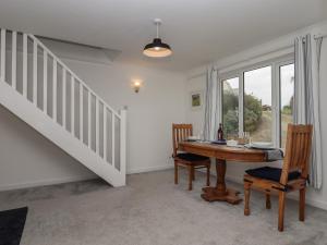 ein Esszimmer mit einem Tisch und einer Treppe in der Unterkunft Northcott View in Bude