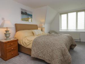 ein Schlafzimmer mit einem Bett und einem Tisch mit einer Lampe in der Unterkunft Northcott View in Bude