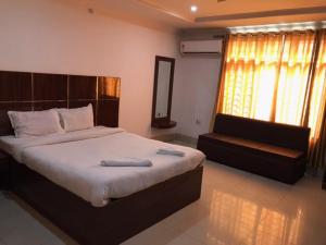 a bedroom with a large bed and a couch at HOTEL SHIVA in Guwahati