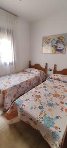 a bedroom with two beds and a window at 28 Gaviotas in Calabardina