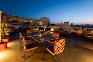a patio with a table and chairs on a roof at Sterling Jaisinghgarh Udaipur in Udaipur