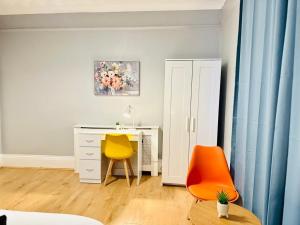 a room with a desk and a yellow chair at Sandys Holidays Home in Clacton-on-Sea