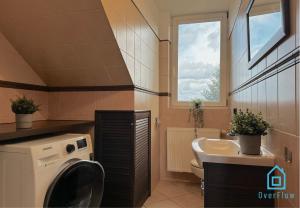 - une buanderie avec un évier et un lave-linge dans l'établissement Purple Room, à Gdańsk
