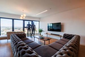 a living room with two brown leather couches and a tv at Panorama Capital Skyline - 17 piętro in Rzeszów