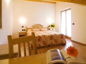 Un dormitorio con una cama y una mesa con un libro en Agritur Girardelli, en Riva del Garda