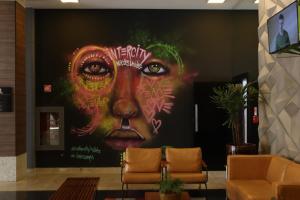 een grote muurschildering van een vrouw met een gezicht bij Intercity São Paulo Nações Unidas in Sao Paulo