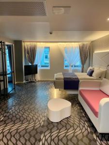 um quarto amplo com 2 camas e uma televisão em Magic Hotel & Apartments Kløverhuset em Bergen