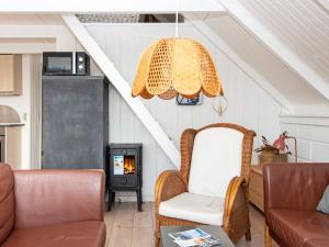 een woonkamer met een stoel en een open haard bij 6 person holiday home in Ringk bing in Ringkøbing