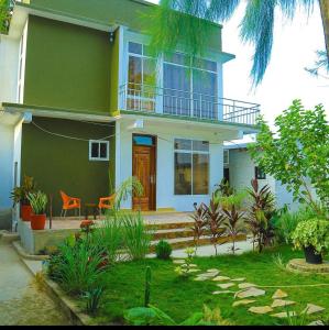uma casa verde com um alpendre e uma varanda em A Gorgeous Condo with a kingsize bed em Dar es Salaam