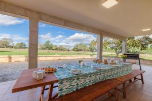 uma sala de jantar com uma mesa com comida em YourHouse Sa Garriga Finca Darder villa em Ariany