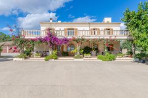 uma casa grande com flores em frente em YourHouse Sa Garriga Finca Darder villa em Ariany
