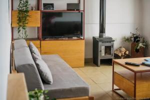 uma sala de estar com um sofá e uma televisão de ecrã plano em Casa Bellavista Ushuaia em Ushuaia