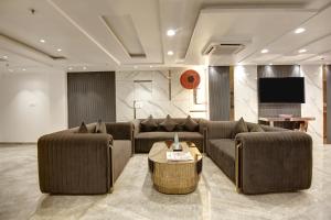 a living room with two couches and a tv at Hotel Kaca Inn-by Haveliya Hotels in New Delhi